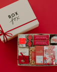 Gift box with various products on a red background, featuring the brand 'Box Fox'.
