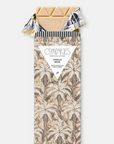 Vanilla bean chocolate bar open with a tan all over palm tree wrapper on white background