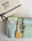 The GREEN GODDESS gift box in creme, including lemongrass body polish, medium candle, dry brush, collagen face mask, hand cream, scalp scrubber, silk scrunchie and hair towel.