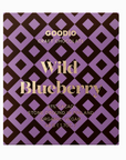 White background with chocolate bar in the center of the shot in purple and black designed packaging with gold lettering on the front that reads "Wild Blueberry"