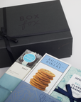 Black gift box with 'Box Fox' branding, featuring cookies and a caramel product on a white background.