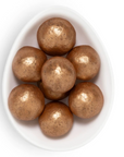 Brown spherical objects in a white bowl on a white background
