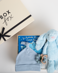 Baby gift set with blue hat, soft toy, and book on a white surface, featuring 'Box Fox' brand.