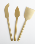 Three gold butter knives on a white background
