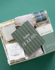 Gift set with bath products and a card on a green background
