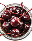 Jar of maraschino cherries on a white background