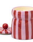 Striped ceramic jar with a candle inside on a white background