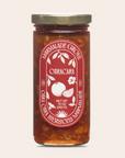 Jar of Caracara marmalade with a red label on a light gray background