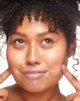 Woman pointing to her face with a clear sheet over it on a white background