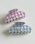 Two checkered bunny-shaped hair clips on a light gray background