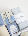 Assorted self-care items including tea packages, socks, and shower steamers on a white background.
