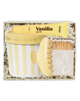 Set of beauty items including a lip balm, scrub brush, and matches in a gift box labeled 'Vanilla'.