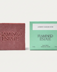 A bar of Flaming Estate soap in a dusty rose color stands next to its mint green packaging box labeled 'Jasmine Damask Rose'.