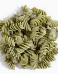 A pile of green rotini pasta on a clean white background with a soft shadow.