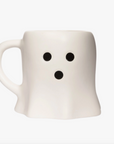 A white ceramic mug shaped like a ghost with a simple black face made of two eyes and a mouth, shown on a plain white background.