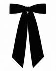A black velvet hair bow accessory with long ribbon tails, featuring the word 'Tiffany' embroidered in white script on one tail, shown tied around a blonde person's hair against a white brick wall.