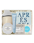 A curated gift box set containing a beige ceramic mug with a white lid, a blue tube of Easy Beauty cream, a round white soap dish, a tea bag packet, and a blue circular sticker, all arranged in white shredded paper inside a light wood box.