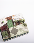 A gourmet gift box from Rustic Bakery featuring assorted chocolates, caramel candies, green pistachio-covered chocolates, and popcorn, arranged in a striped green and white box with a green ribbon.