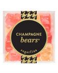 A clear square plastic container filled with pink and orange gummy bears, with a black circular label reading 'CHAMPAGNE bears' and 'sugarfina' on a white background.