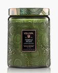 Green embossed candle jar with Voluspa label on a white background