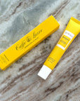 Caffe Luxe lip balm packaging on a marble surface