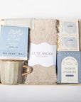 Gift set with mug, socks, and shower steamers on a white background