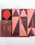 A boxed food product set on a white background, featuring a pink and dark brown geometric package labeled GOODINO Ginger Bread, alongside a smaller brown box labeled GOODINO Hot Cocoa and a round red sticker reading Dark Chocolate Candies.