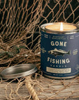 Gone Fishing candle in a blue can with a fish illustration on a fishing net background