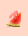 Slice of watermelon with a piece of pink grapefruit on a light pink background