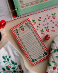 cherry notepad on a table with a cherry mug card towel and mit