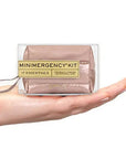 Minimergency kit held in a hand on a white background