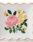 white rectangular ring dish with scalloped edges. in the center is a rose