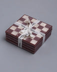 Set of checkered coasters tied with a ribbon on a gray background