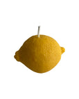 Yellow lemon-shaped candle on a white background