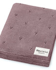 Brown knit blanket with small patterns and Bleu-La-La label on a white background