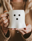 girl holding a ghost coffee mug