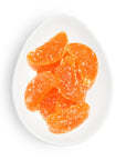 Orange candy pieces on a white plate with a white background