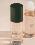 Two bottles of 'Belly Oil' by Hatch Mama on a light background