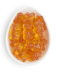 Orange gummy bears in a white bowl on a white background