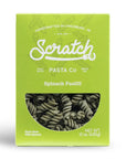 A bright lime green box of Scratch Pasta Co. Spinach Fusilli pasta, featuring a clear window on the front showing the dark green spiral pasta inside.