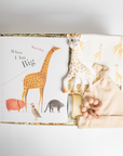 children's book, giraffe onesie, yellow hat, teether, baby lotion, and giraffe toy packed in a creme BOXFOX