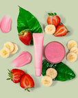 pink lip balm surrounded by strawberries & bananas