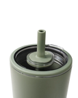 Close-up of a matte sage green tumbler with a matching silicone straw lid insert and clear plastic rim, shown on a white background.