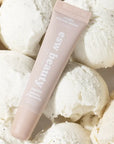 Pink tube of Easy Bama bath butter surrounded by white bath bombs.