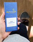 Hand holding a Moonstruck dark chocolate bar packaging