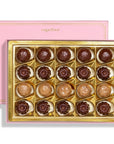 A Sugarfina chocolate box with 18 assorted chocolates arranged in a gold tray, shown with its pink lid behind it on a white background.