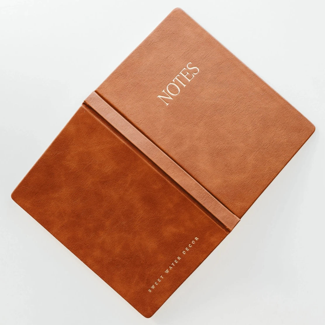 open brown leather journal that says 'NOTES' on it in gold