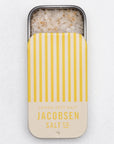 beige and yellow stripped salt tin slid down with salt and lemon flakes in it