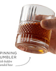 Hand holding a glass of amber liquid with text describing the 'Spinning Tumbler'.