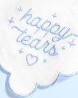 White cloud-shaped pillow with 'happy tears' text embroidered in blue on a light blue background